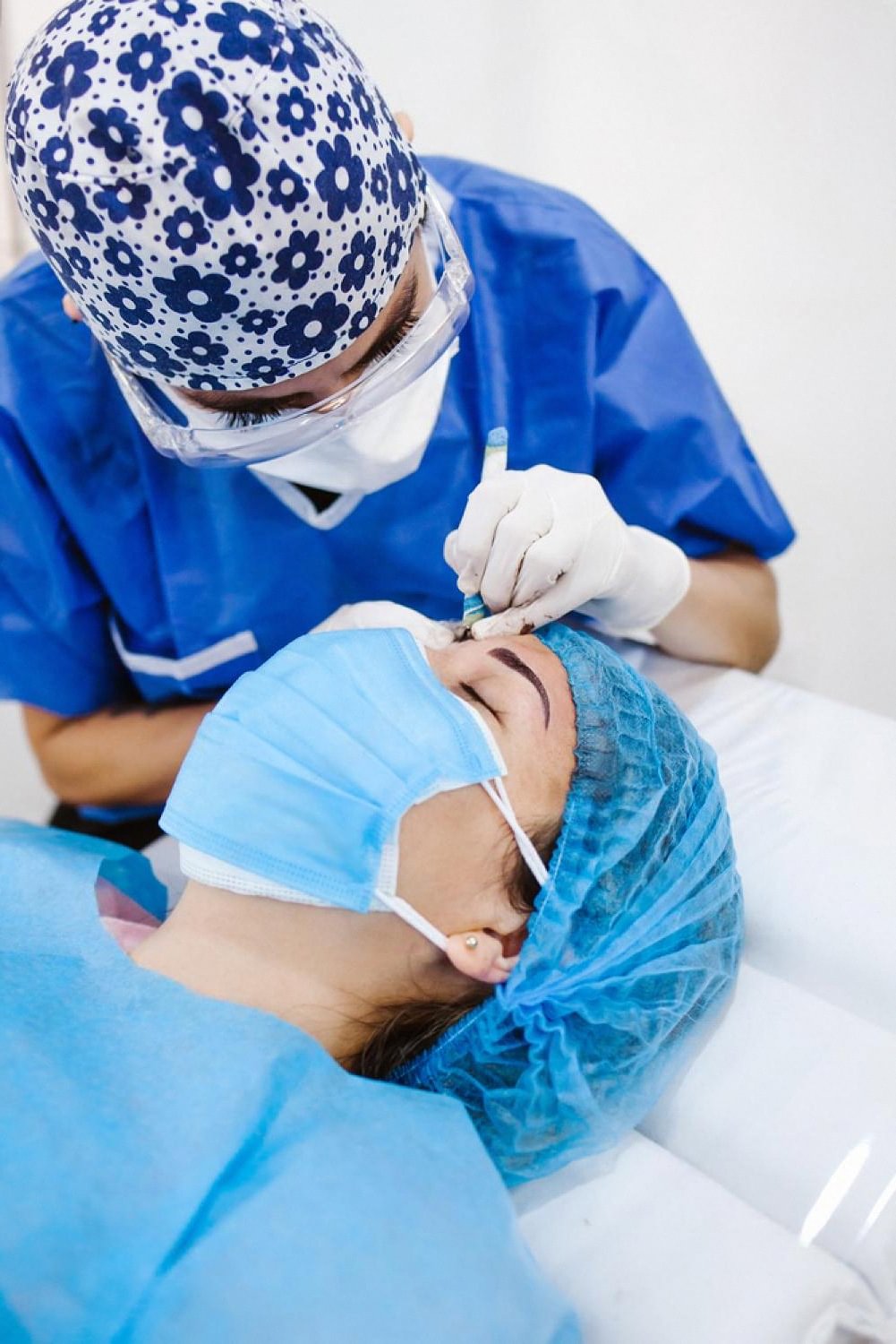 Dermatologist in blue scrubs performing a facial skin treatment on a patient in a UAE clinic